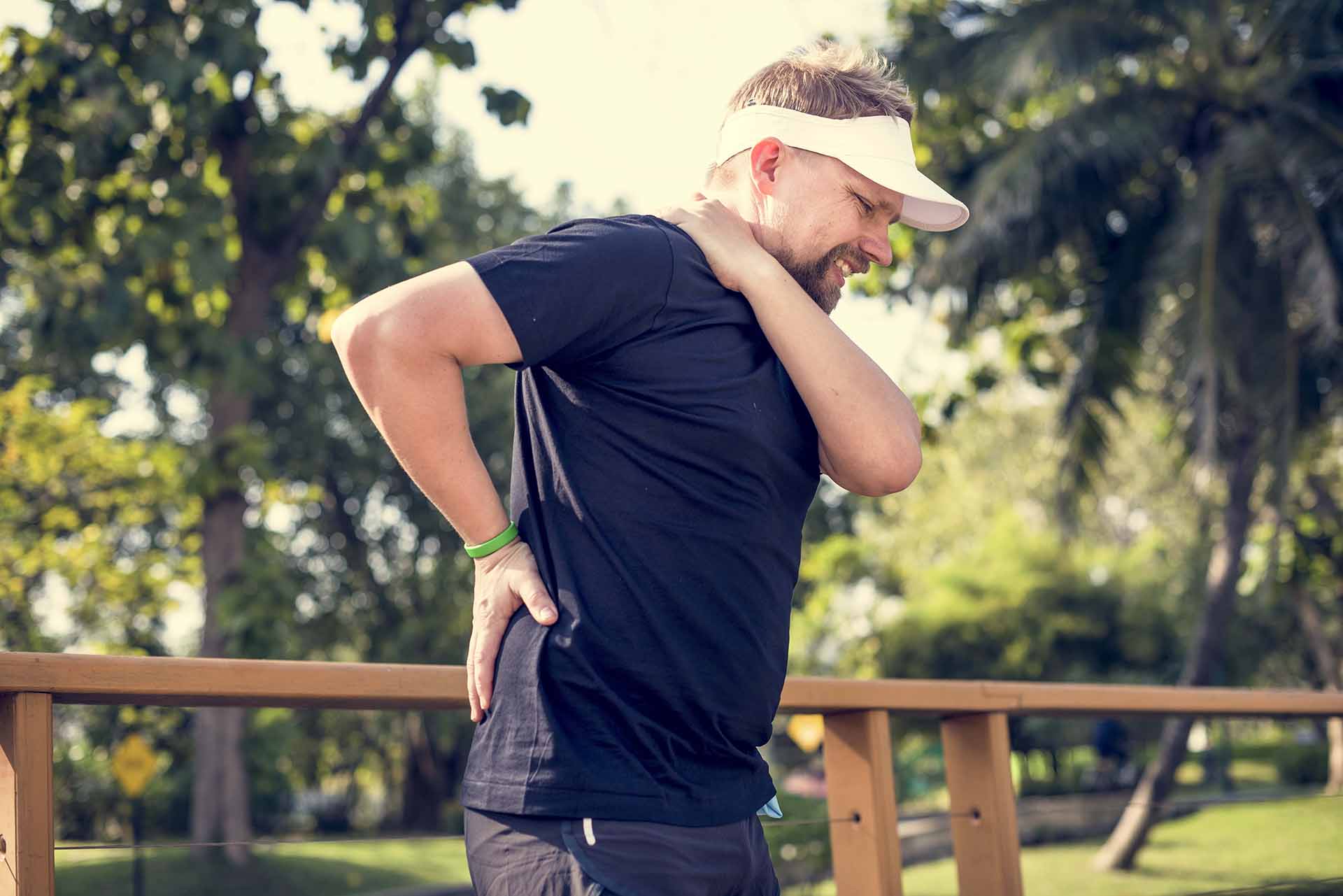 Man with fibromyalgia holds shoulder and back that causes him pain